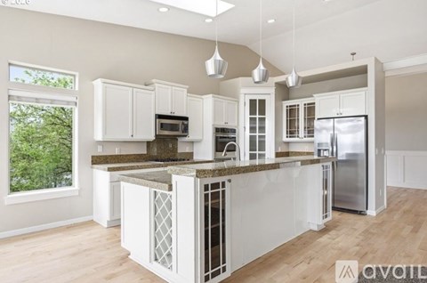 A kitchen with white cabinets and a granite countertop.