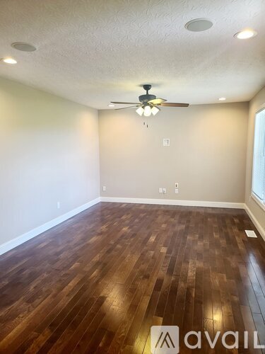 A room with wooden flooring and a ceiling fan.