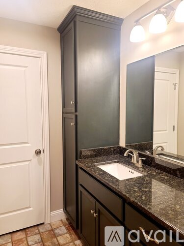A bathroom with a sink and a cabinet.