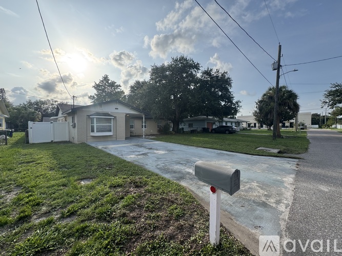 A sunny day in a residential area with houses and a mailbox.