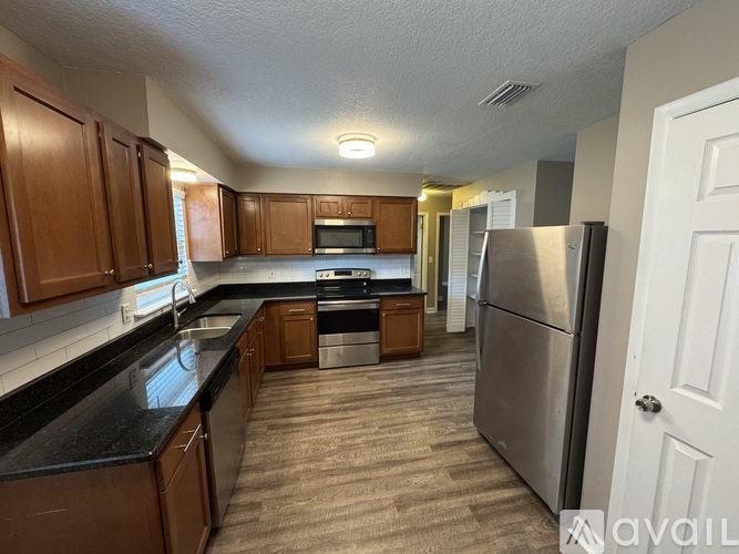 A kitchen with wooden cabinets and a black countertop.