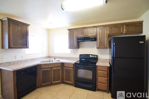 A kitchen with wooden cabinets and black appliances.
