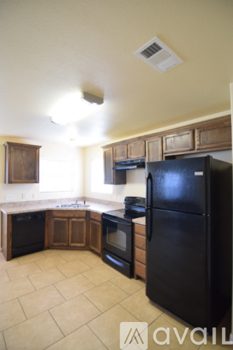 A kitchen with black appliances and wooden cabinets.