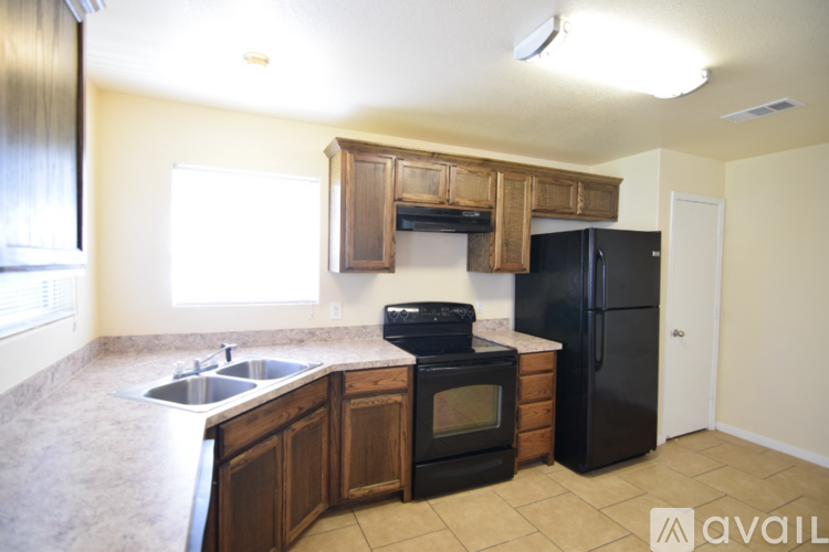 A kitchen with wooden cabinets and black appliances.