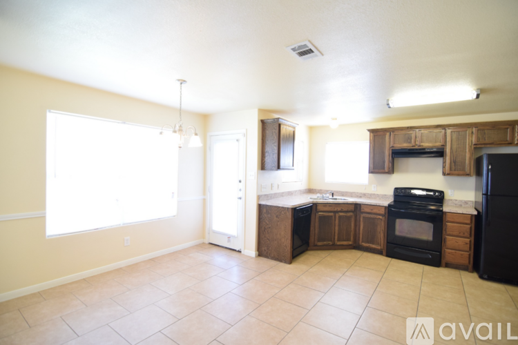 A kitchen with black appliances and wooden cabinets.