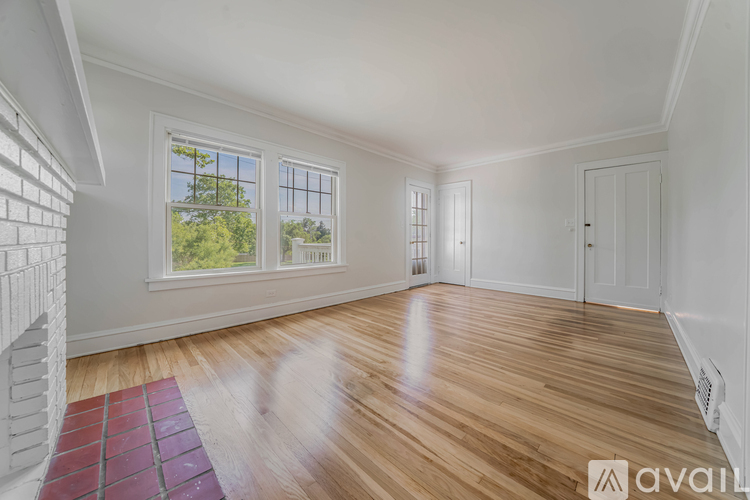 A room with wooden floors and a large window.