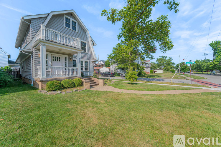 A house with a large front yard and a tree in the front.