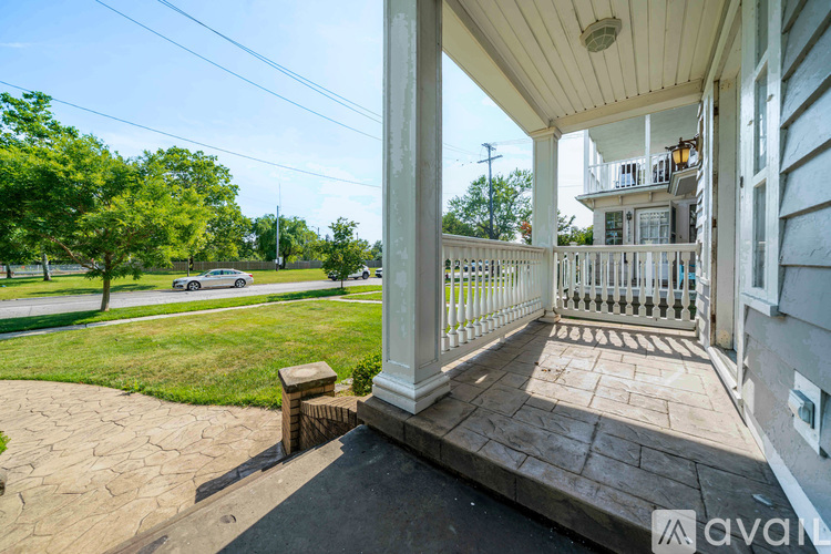 A porch with a white railing and a pillar.