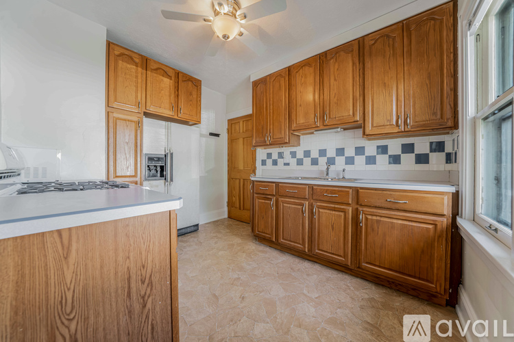 A kitchen with wooden cabinets and a checkered backsplash.