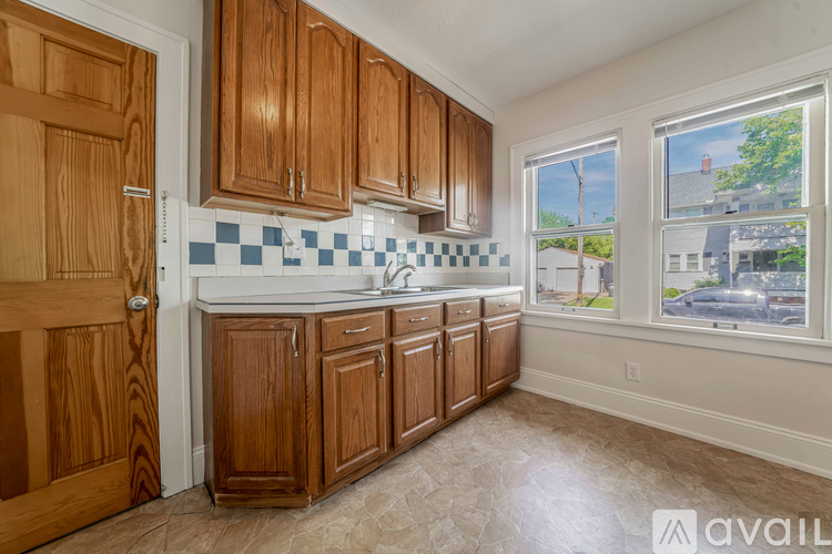 A kitchen with wooden cabinets and a checkered backsplash.
