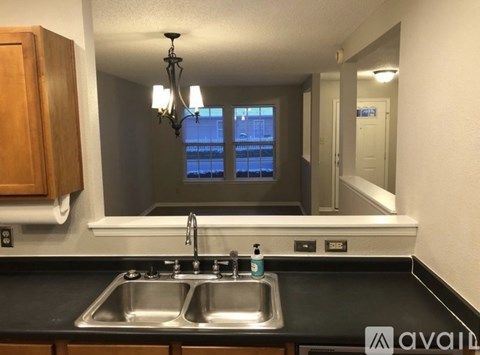 A kitchen with a sink and a chandelier.