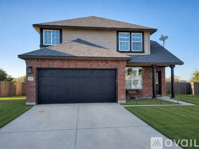 A house with a black garage door and a brick chimney.