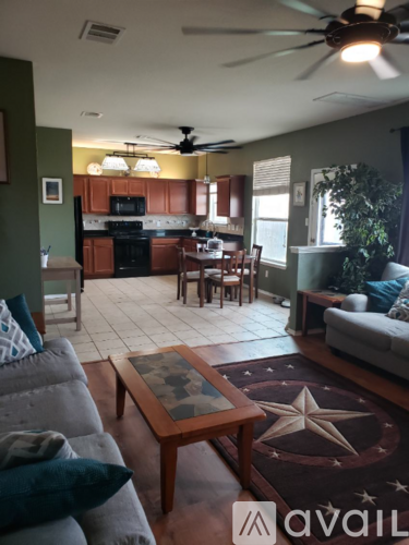 A living room with a couch, coffee table, and a ceiling fan.