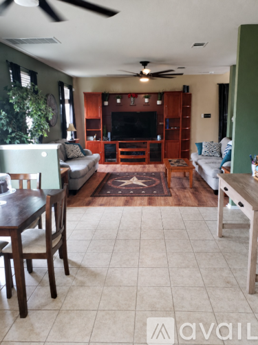 A living room with a couch, a chair, a table and a television.