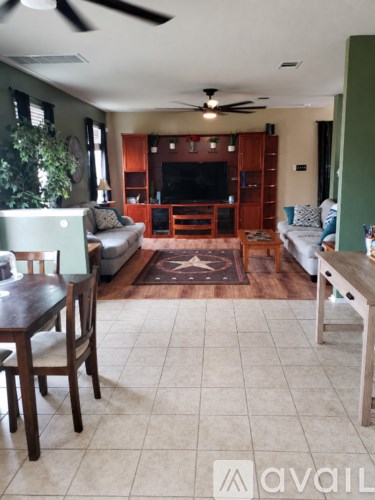 A living room with a couch, a chair, a table and a television.