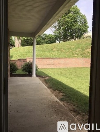 A view from a covered walkway looking out to a green lawn.