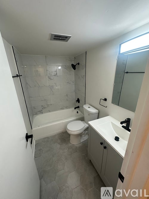 A bathroom with a toilet, sink, and bathtub.