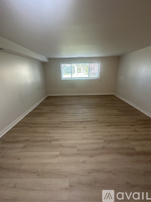 A room with wooden flooring and a window.