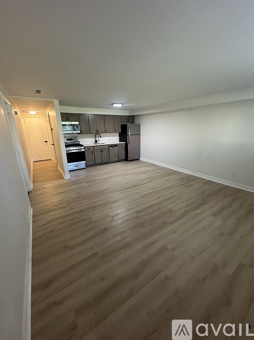 A kitchen area with wooden flooring and a countertop.