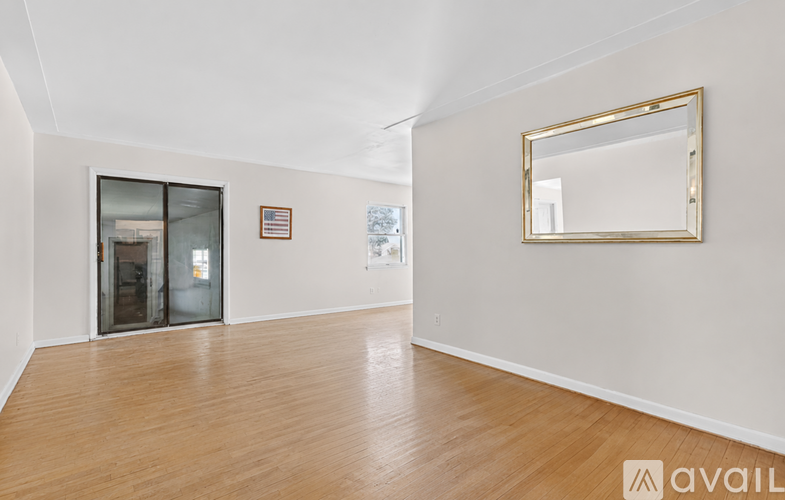 A room with a wooden floor and a mirror on the wall.