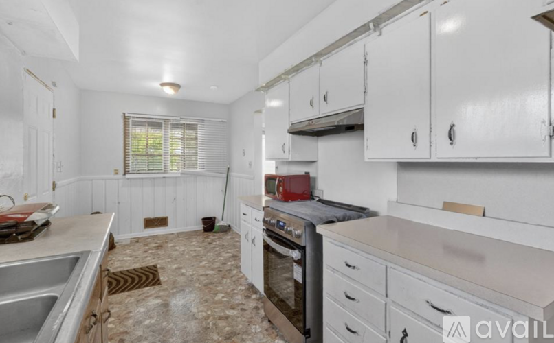 A kitchen with white cabinets and a tiled floor.