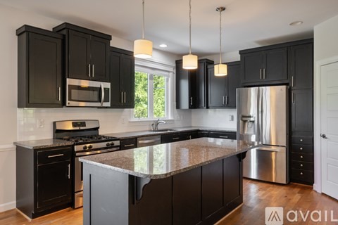 A kitchen with black cabinets and a granite countertop.