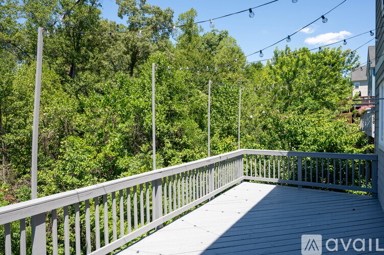 A deck with a railing and trees in the background.