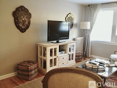 A living room with a television on a stand and a chair in front of it.