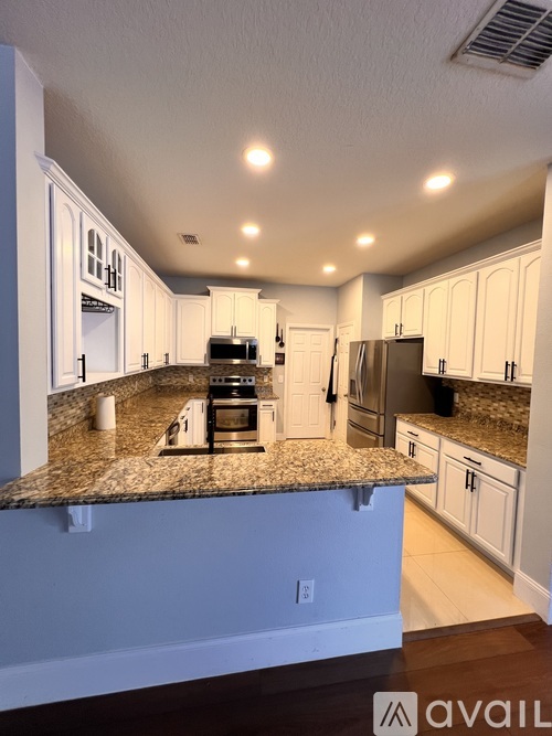 A kitchen with granite countertops and stainless steel appliances.