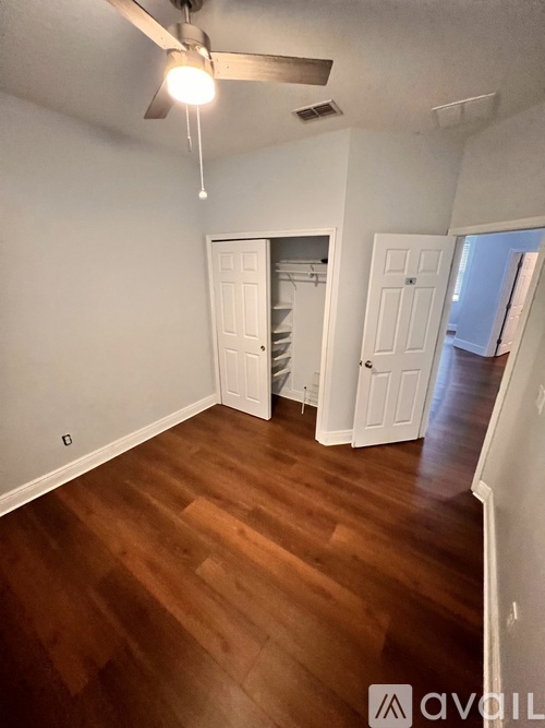 A room with wooden floors and a ceiling fan.