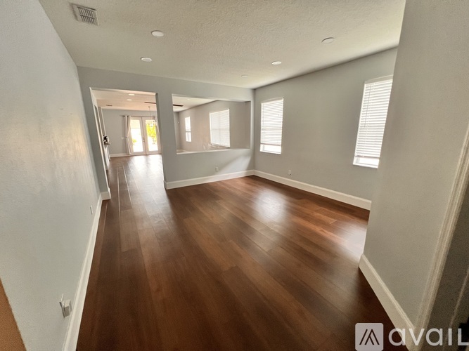 A spacious room with wooden floors and white walls.