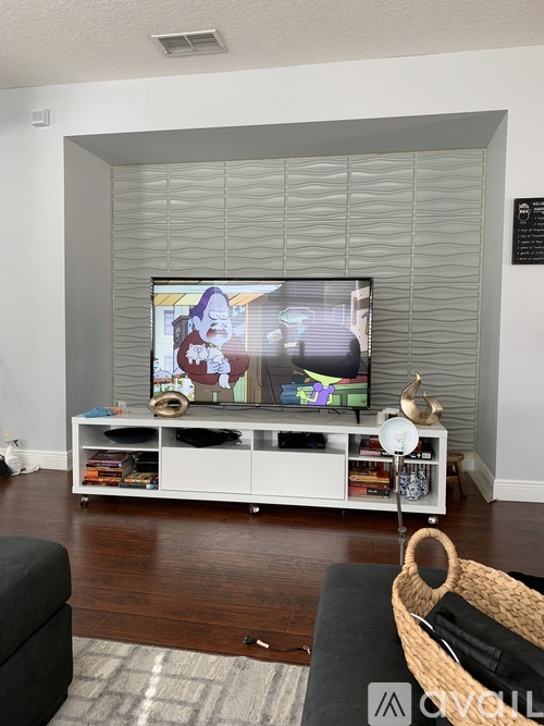 A living room with a television on a white stand.