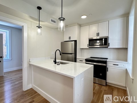A kitchen with white cabinets and a marble countertop.