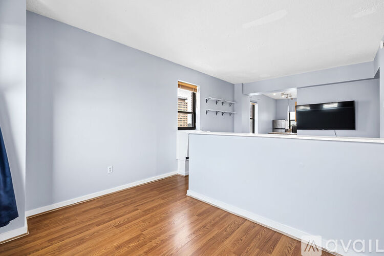 A spacious room with a wooden floor and a white wall.
