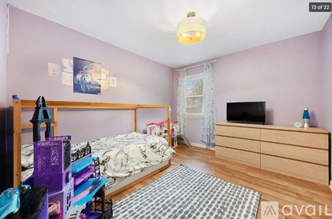 A bedroom with a bed, a dresser, and a television.
