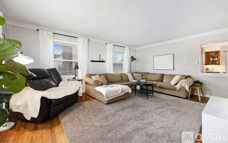 A living room with a black leather chair and a grey sofa.