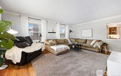 A living room with a black leather chair and a grey sofa.