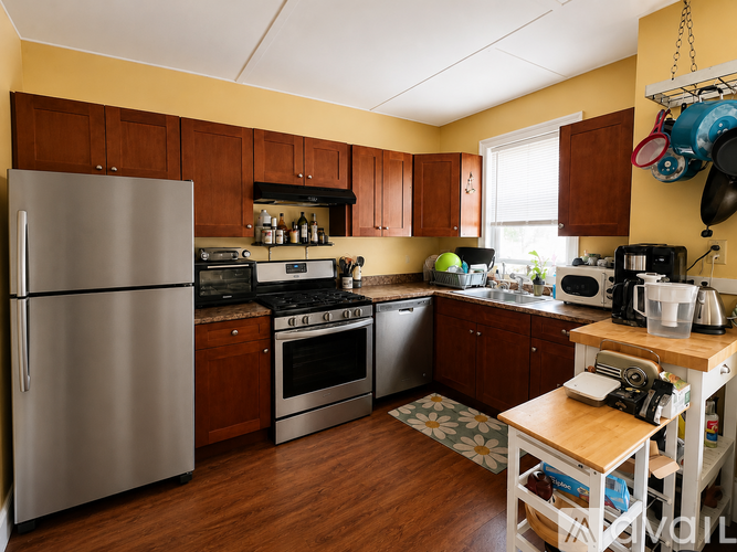 A kitchen with a refrigerator, oven, and microwave.