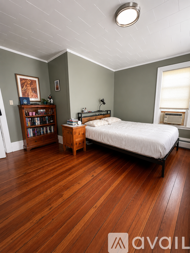A bedroom with a bed, nightstand, and bookshelf.