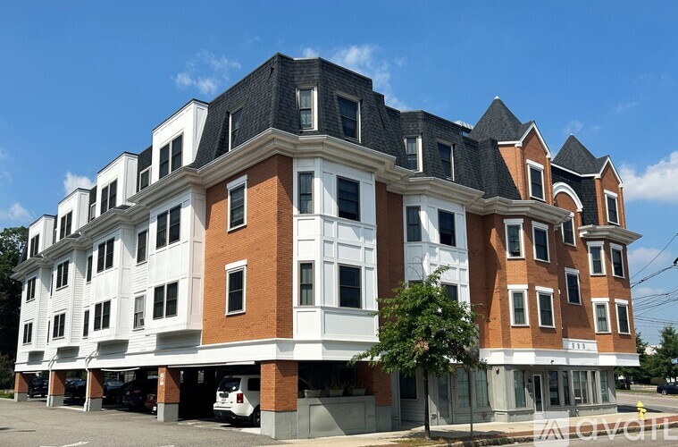 A large, multi-story building with a combination of white and brick facades.