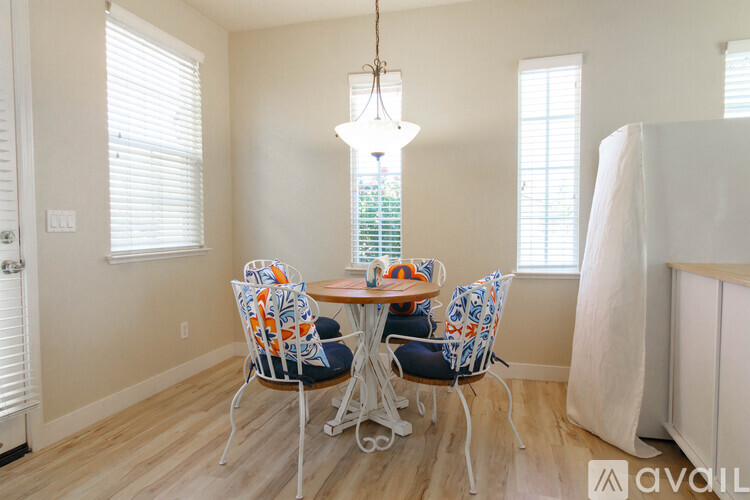 A dining room with a round table and four chairs.