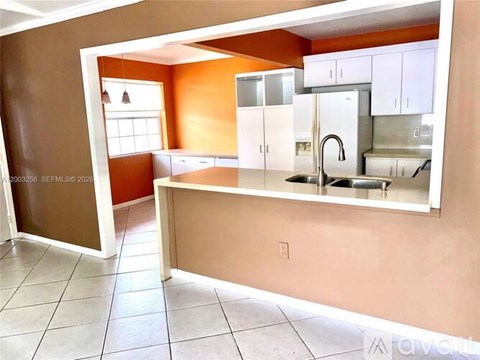A kitchen with white cabinets and a countertop.