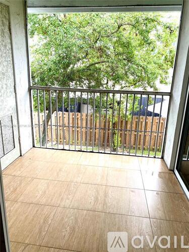 A balcony with a view of a backyard and trees.