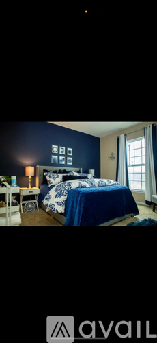 A bedroom with a bed covered in a blue comforter.