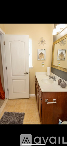 A bathroom with a white door, a sink, and a mirror.
