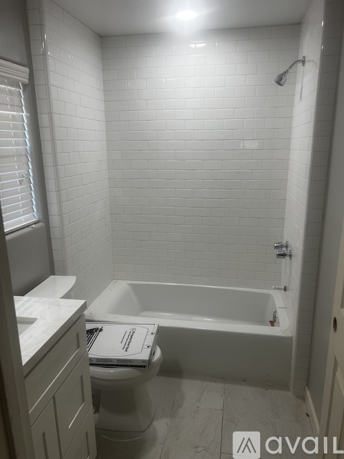 A white bathroom with a toilet, sink, and bathtub.