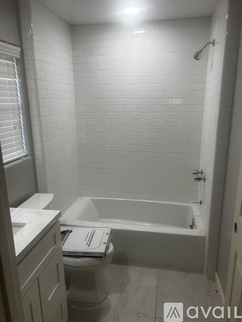 A white bathroom with a toilet, sink, and bathtub.