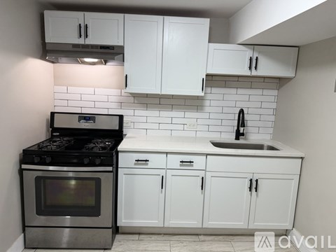 A kitchen with white cabinets and a black stove top oven.