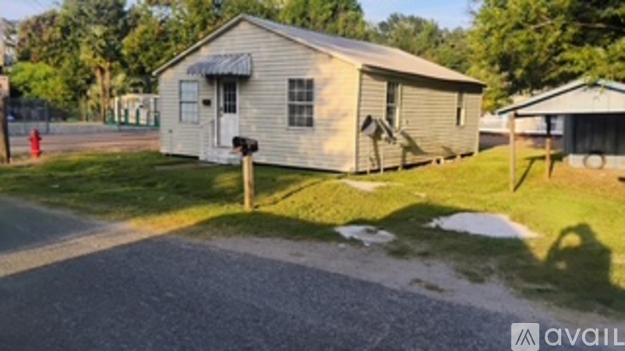 A small house with a porch and a mailbox in front.