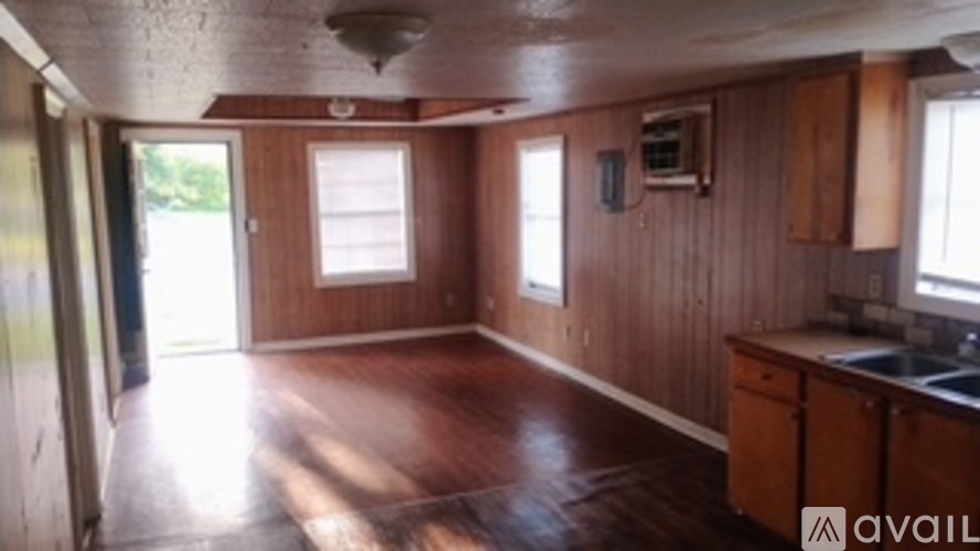 A room with wooden walls and floor and a window.